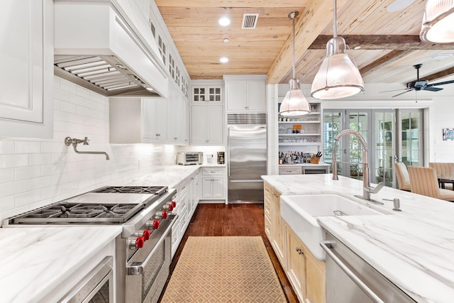 kitchen featuring ceiling fan, premium appliances, tasteful backsplash, hanging light fixtures, and premium range hood