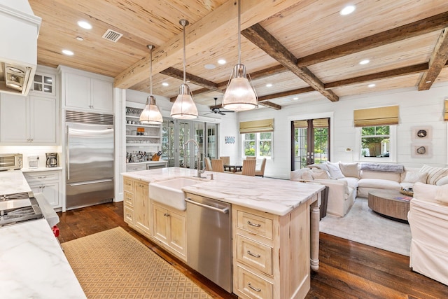 kitchen featuring appliances with stainless steel finishes, dark wood-type flooring, and a kitchen island with sink