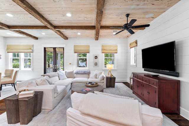 living room featuring wood-type flooring, a wealth of natural light, beam ceiling, and ceiling fan