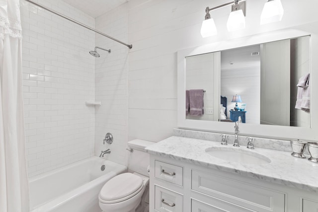 full bathroom with vanity with extensive cabinet space, tiled shower / bath combo, and toilet