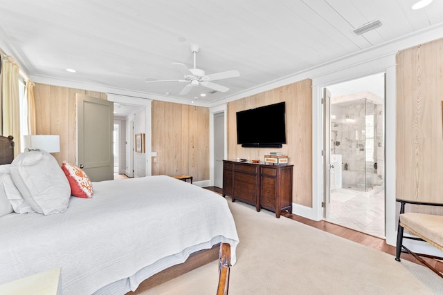 bedroom with crown molding, ensuite bath, light hardwood / wood-style floors, and ceiling fan