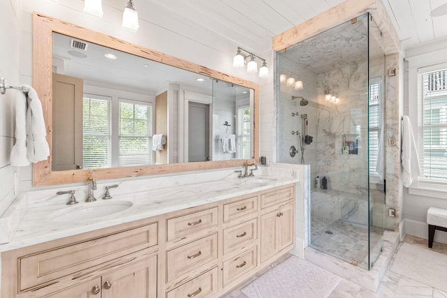 bathroom featuring a shower with door, oversized vanity, a healthy amount of sunlight, and double sink