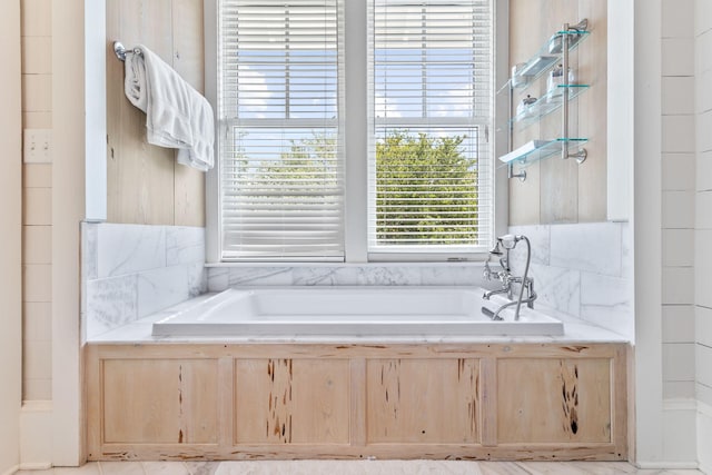 bathroom featuring a relaxing tiled bath and tile flooring