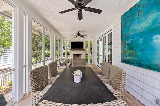 sunroom / solarium featuring exterior fireplace, wood ceiling, and ceiling fan