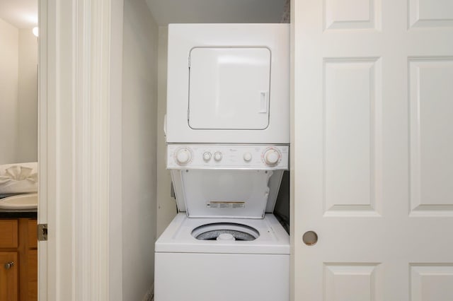 clothes washing area featuring stacked washing maching and dryer