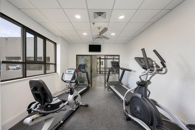 gym with ceiling fan and a drop ceiling