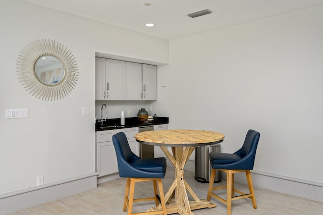 dining space featuring sink and light wood-type flooring