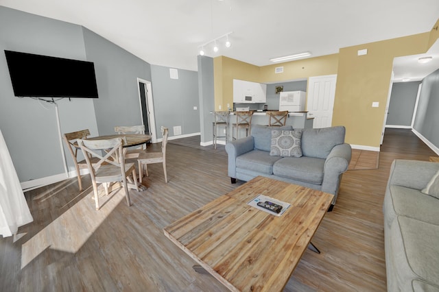 living room with wood-type flooring and track lighting