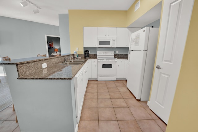 kitchen featuring rail lighting, white appliances, kitchen peninsula, and light tile floors