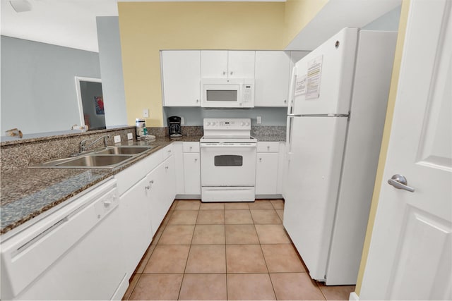 kitchen featuring sink, white appliances, light tile flooring, and white cabinetry