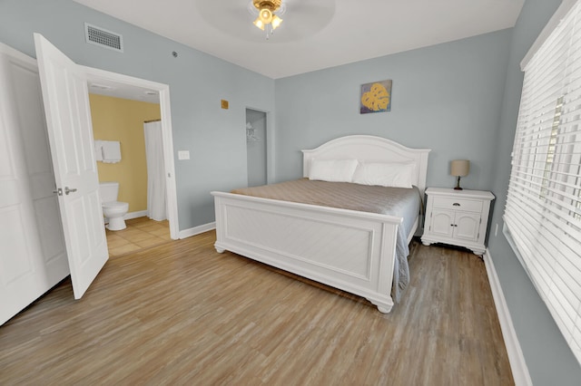 bedroom featuring ensuite bath, ceiling fan, and light tile floors