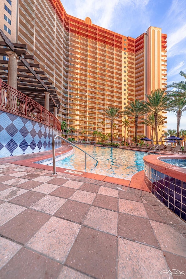 view of pool with a patio area and a hot tub