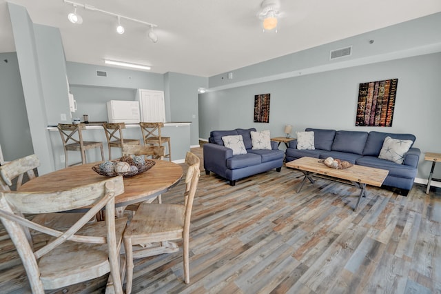 living room with hardwood / wood-style flooring and track lighting