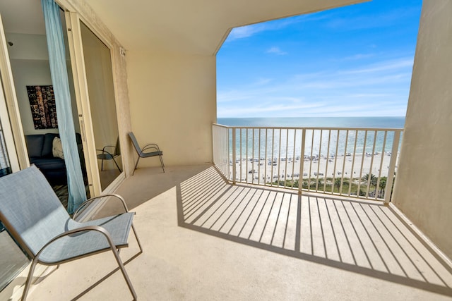 balcony featuring a beach view and a water view