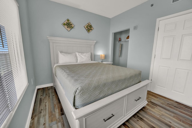 bedroom with wood-type flooring and multiple windows