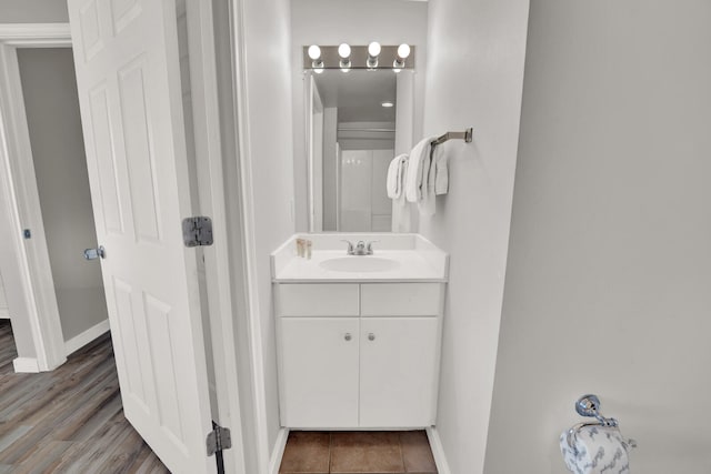 bathroom featuring wood-type flooring and vanity with extensive cabinet space