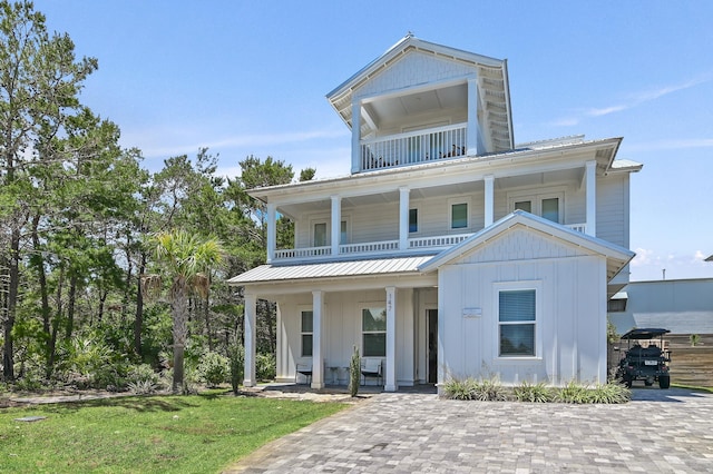 view of front of property with a balcony and a front lawn