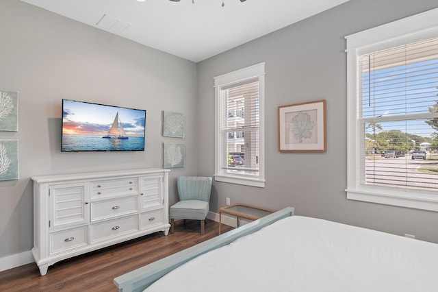 bedroom featuring dark hardwood / wood-style floors, ceiling fan, and multiple windows