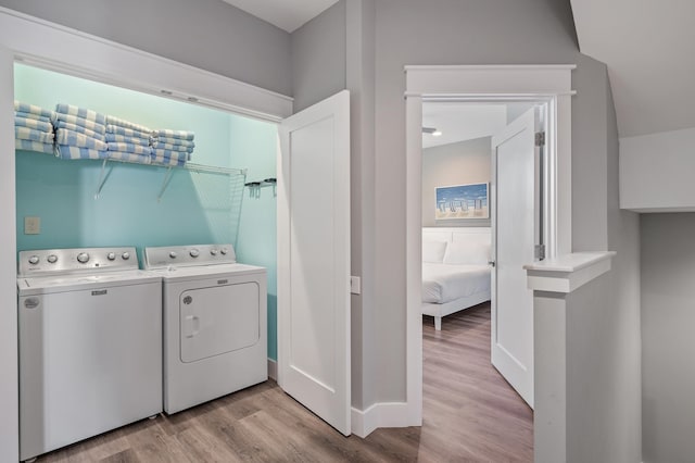 laundry area with light hardwood / wood-style flooring and washer and clothes dryer