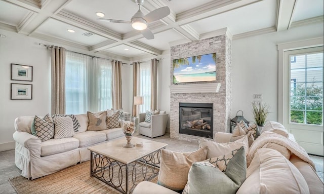 living room with beam ceiling, a stone fireplace, coffered ceiling, and crown molding