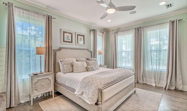 bedroom featuring hardwood / wood-style flooring, ceiling fan, and crown molding