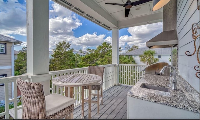 wooden deck featuring ceiling fan, sink, and exterior kitchen