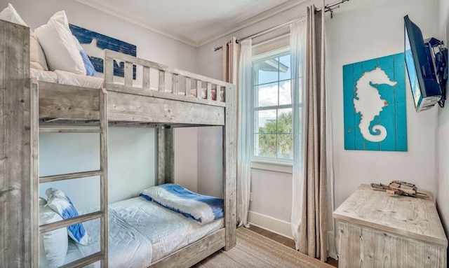 bedroom with hardwood / wood-style floors, crown molding, and multiple windows