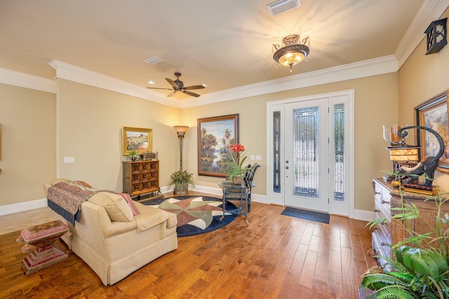 living room featuring hardwood / wood-style floors, ceiling fan, and crown molding