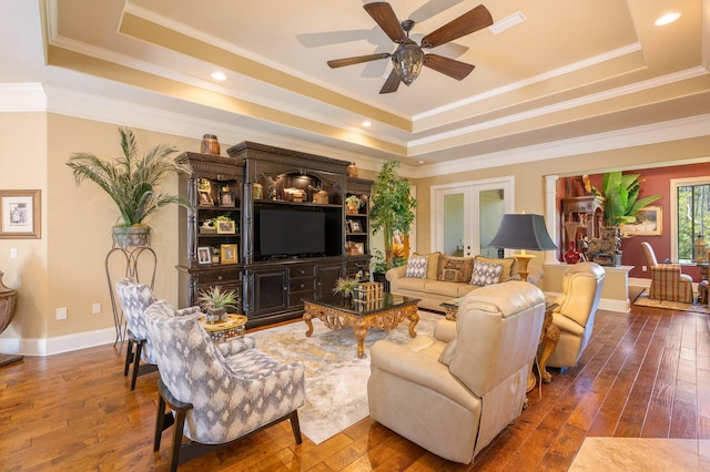 living room featuring french doors, ceiling fan, a tray ceiling, hardwood / wood-style flooring, and ornamental molding