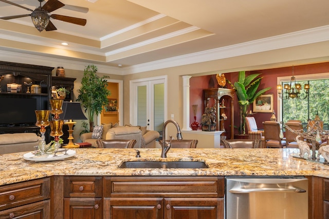 kitchen with sink, dishwasher, ceiling fan with notable chandelier, a raised ceiling, and crown molding