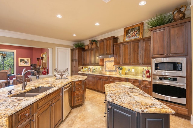 kitchen with appliances with stainless steel finishes, backsplash, light tile flooring, sink, and a center island