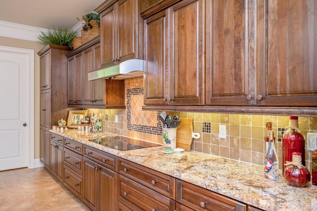 kitchen featuring tasteful backsplash, black electric stovetop, light tile floors, and light stone countertops