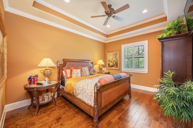 bedroom with dark hardwood / wood-style flooring, ceiling fan, crown molding, and a raised ceiling