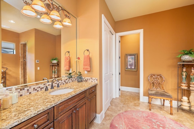 bathroom with tile flooring, vanity, and a notable chandelier