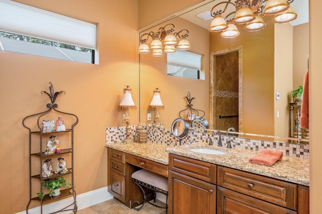 bathroom featuring tile flooring, a notable chandelier, tasteful backsplash, and vanity