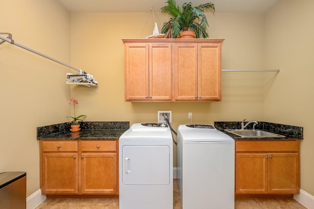 laundry area featuring light tile floors, washing machine and clothes dryer, cabinets, and sink