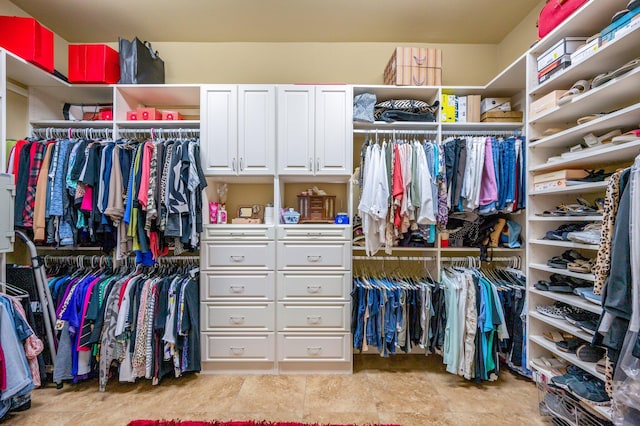 walk in closet with light tile floors