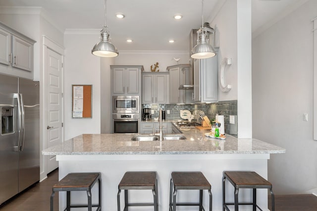 kitchen featuring appliances with stainless steel finishes, kitchen peninsula, backsplash, and decorative light fixtures