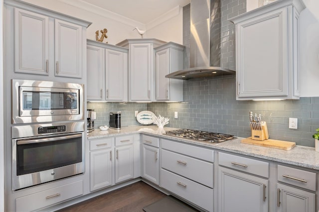 kitchen with crown molding, dark hardwood / wood-style flooring, backsplash, wall chimney range hood, and stainless steel appliances