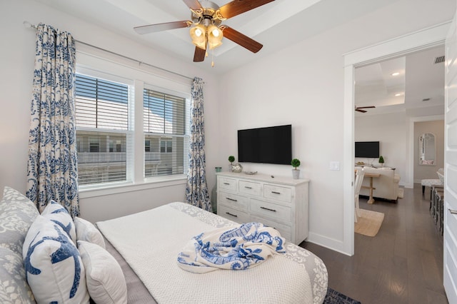 bedroom featuring ceiling fan, a raised ceiling, and dark wood-type flooring