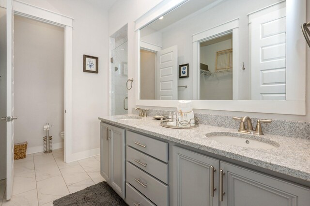 bathroom featuring double vanity, tile flooring, and toilet