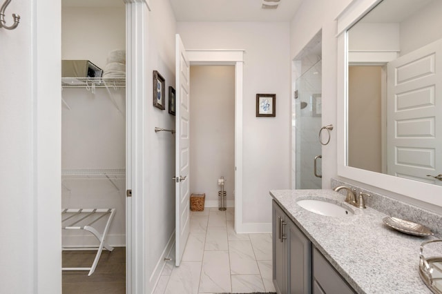 bathroom featuring walk in shower, vanity, and tile floors