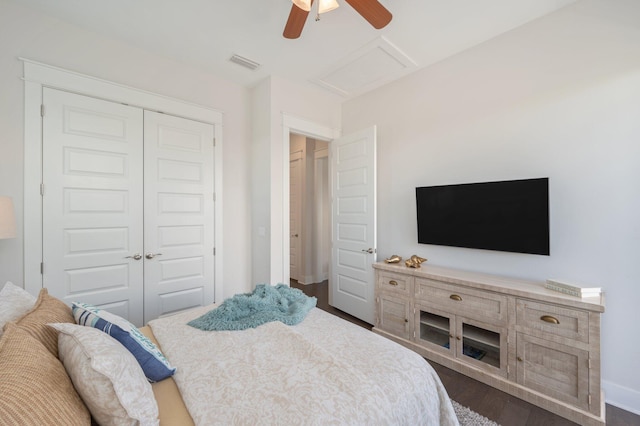 bedroom with dark hardwood / wood-style flooring, ceiling fan, and a closet