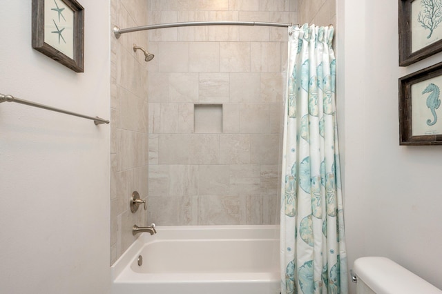 bathroom featuring toilet and shower / bath combination with curtain