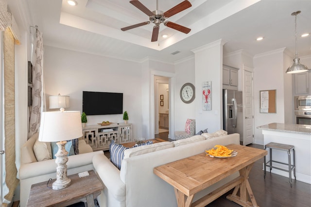 living room featuring ceiling fan, crown molding, a tray ceiling, and dark hardwood / wood-style floors