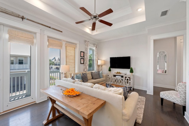 living room featuring ornamental molding, ceiling fan, a raised ceiling, and dark wood-type flooring