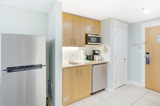 kitchen with stainless steel appliances, sink, tasteful backsplash, and light tile floors