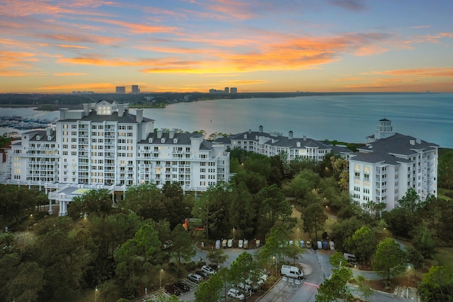 aerial view at dusk featuring a water view