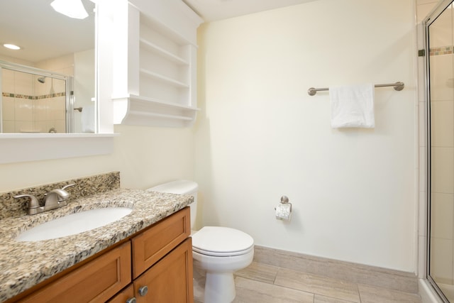 bathroom featuring vanity, an enclosed shower, and toilet