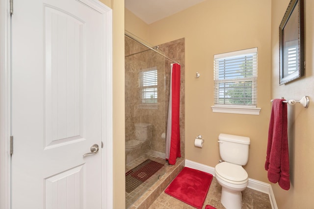 bathroom featuring tile patterned flooring, toilet, and walk in shower